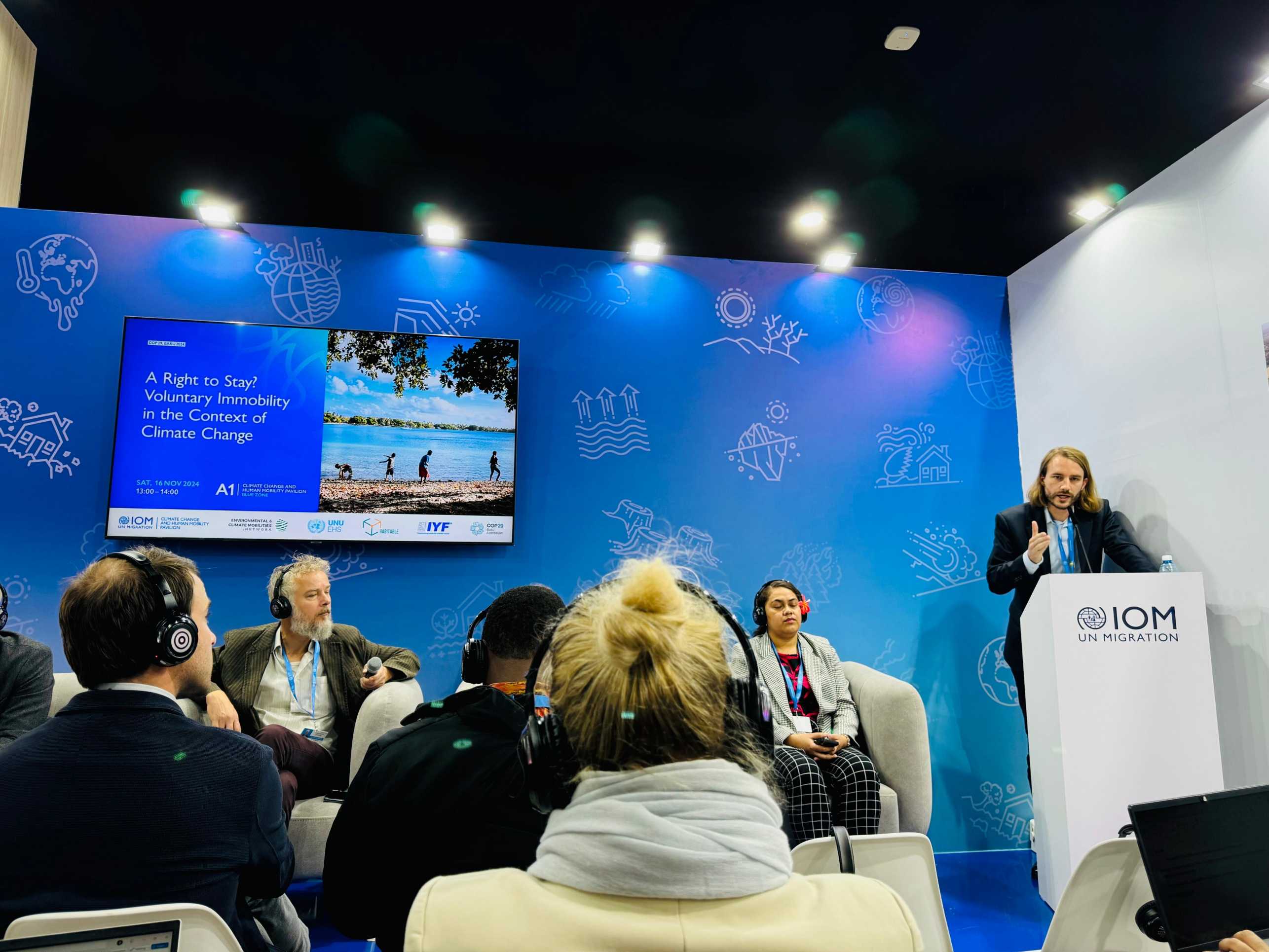 Jan Freihardt speaking at the pavilion of the International Organization for Migration